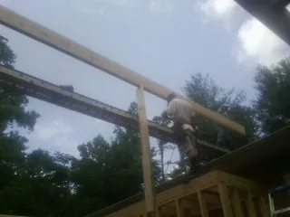 Carpenter setting a ridge beam over a new addition frame — Ice Dam Removal by Roofing Brothers in Pawleys Island