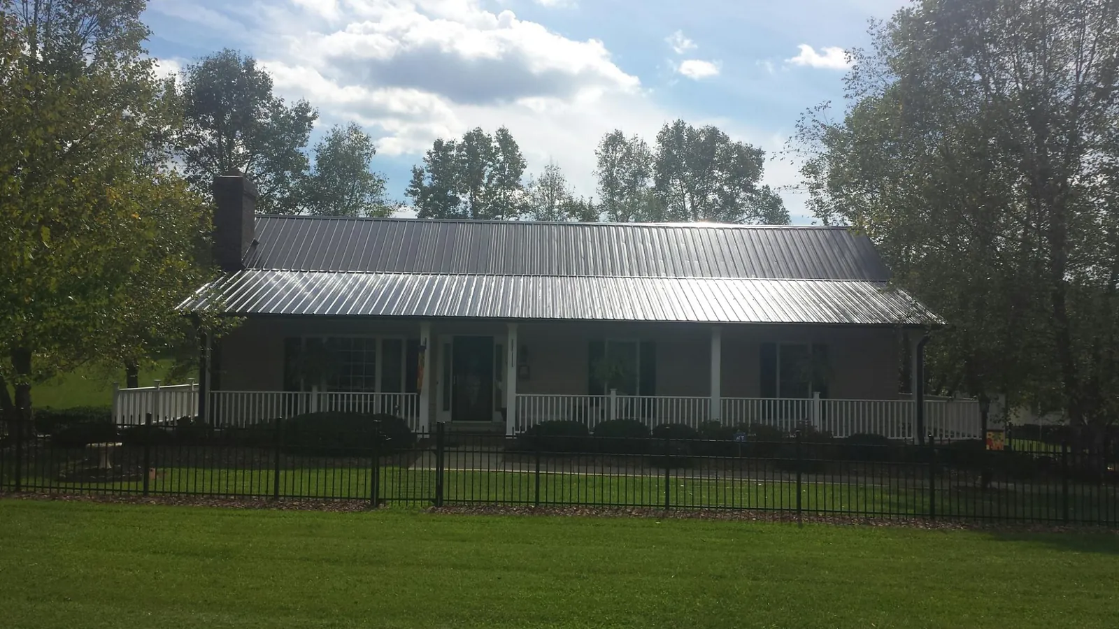 Gray metal roof on a brick ranch with a full width front porch — Gutter Guard Installation work by our crew in Pawleys Island